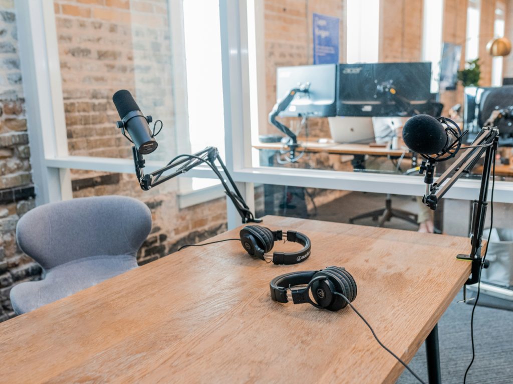 deux microphones sur un bureau avec un ordinateur en arrière-plan