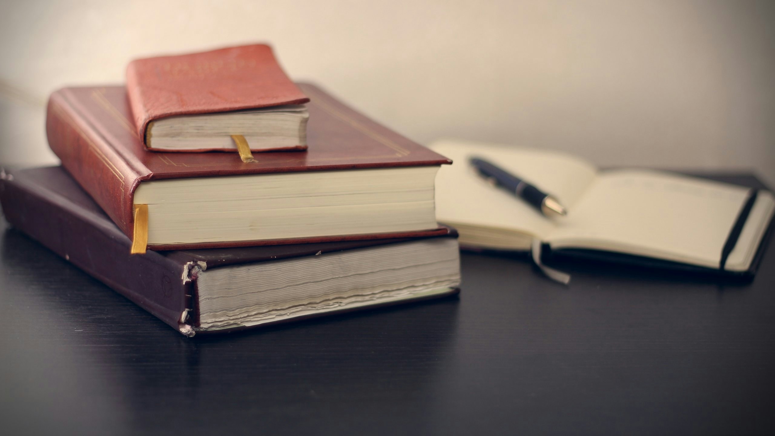 A pile of books on a desk.